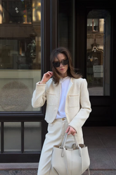a lady in a white top, a white jacket and a pair of white pants